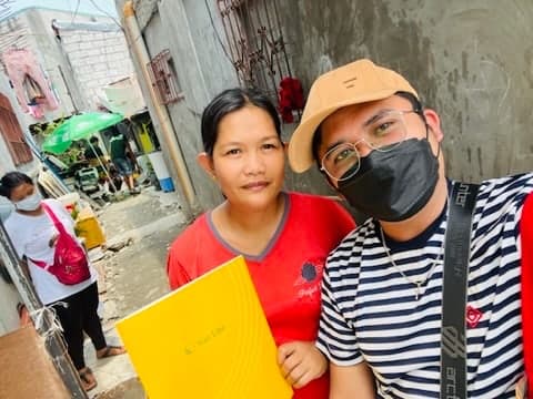 Rodel Hermogenes with a client outside her home, delivering her Sun Life policy in person