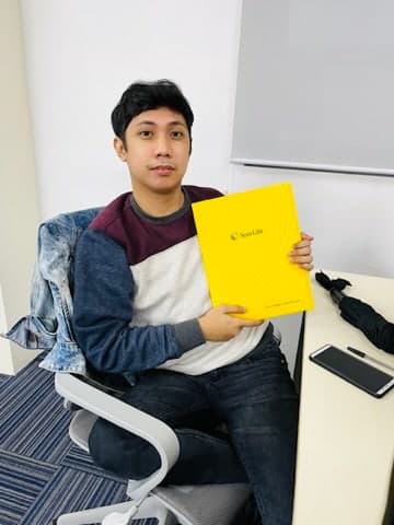 A client seated in a meeting room with his newly issued Sun Life policy